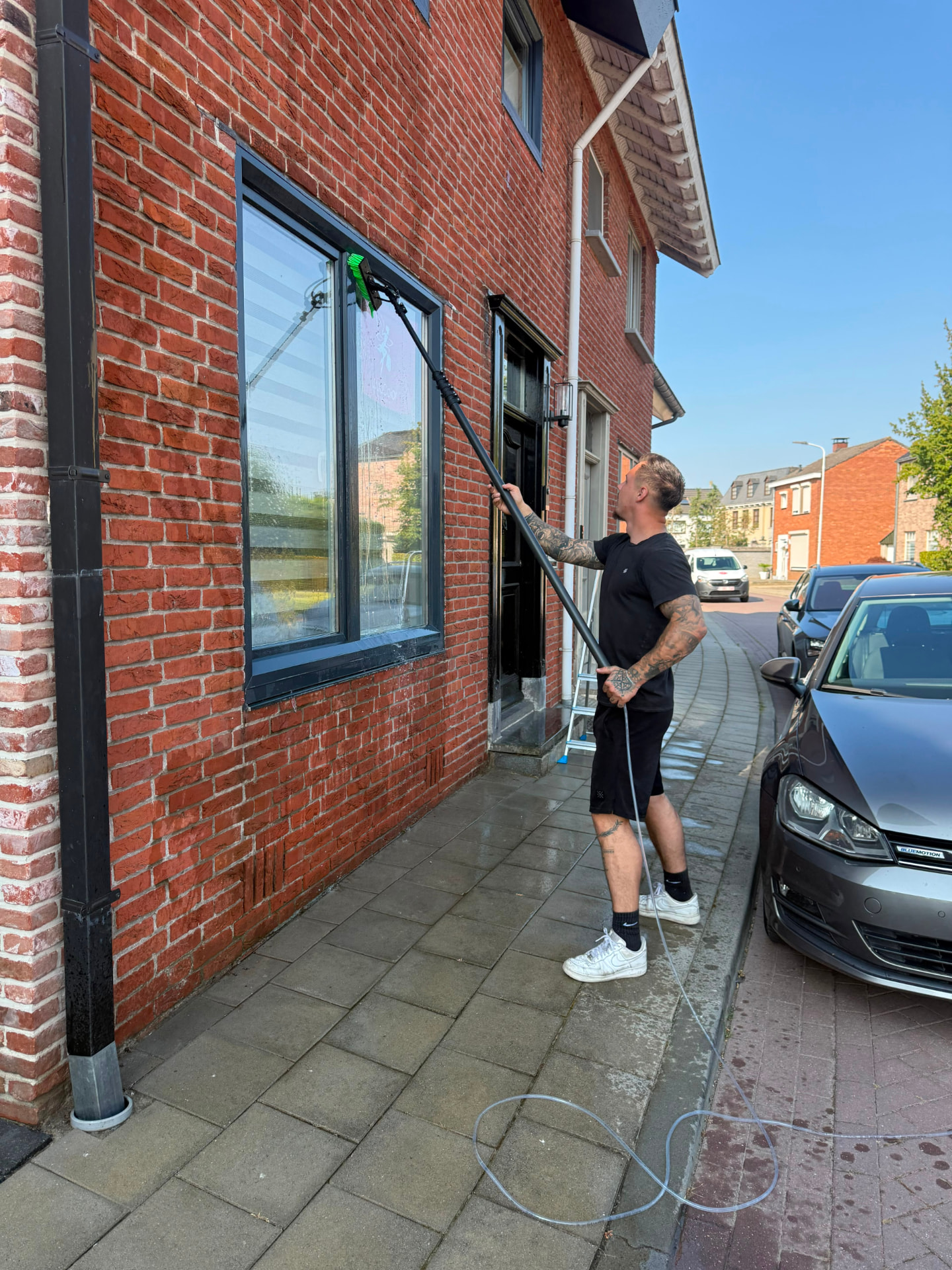 Senne wast ramen met telescoopsteel aan een gevel
