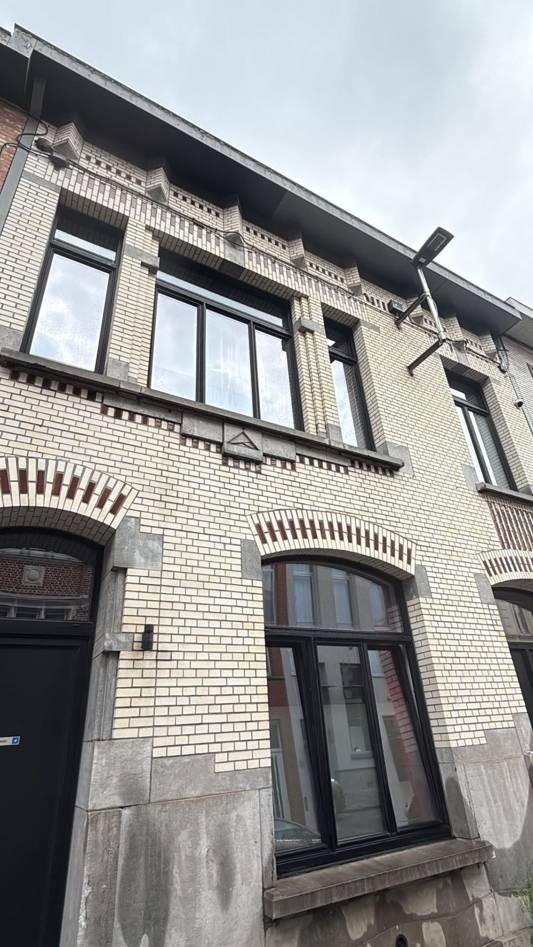 Zwartkaderen ramen van een bakstenen woning, streeploos proper na het raamwassen